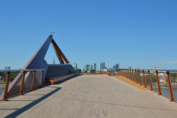 Fototapeta premium New brigde in Warsaw, Poland. Pedestrian and bicycle footbridge over the Vistula River. Warsaw skyline