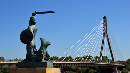 Warsaw, Poland. Statue of Mermaid (Polish: Warszawska Syrenka) symbol of Warsaw by the Vistula river on the background of Swietokrzyski Bridge. Spring time in Warsaw, Poland © PaulSat