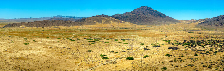 Aerial panoramic view of mountains, Mohave desert and sand drifts against hillsides in the Cronese Valley 