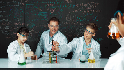 Smart teacher explain about chemical theory while student mixing colored solution or doing...
