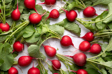 Fresh red organic radish with greens on white table. Top view. Food photography