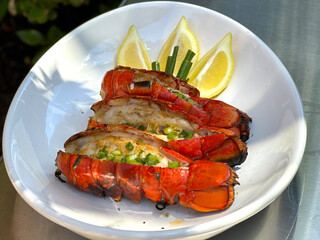 Grilled Lobster Tails with Garlic Lemon Butter Sauce Topped with Green Onions. Closeup Pictures During Preparation and Grilling. Summer Seafood Barbecue  