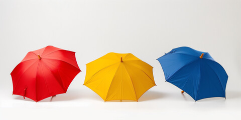 three colorful umbrellas stretched out against a white background, showcasing their vibrant colors and design.