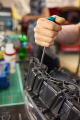 showing hands effectively repairing a car headlight in a workshop environment