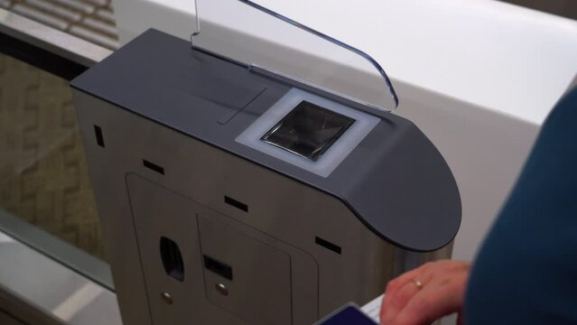Access control systems in international airport. Validator. Checkpoint. Passenger Tapping Boarding Pass At Automated Self-boarding Gate Of An Airport.