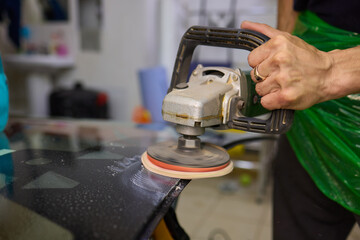 A professional technician expertly polishes glass surfaces in a workshop with precision