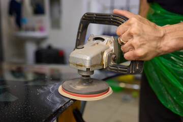 A professional technician expertly polishes glass surfaces in a workshop with precision