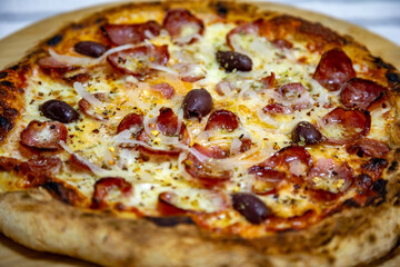 Calabrian sausage pizza served on a round board and set table