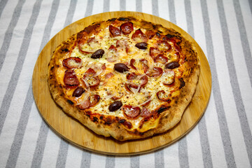 Calabrian sausage pizza served on a round board and set table