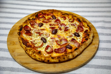 Calabrian sausage pizza served on a round board and set table