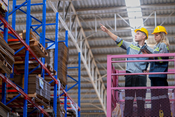 workers man and woman using a hydraulic scissor lift to check stock near the shelves warehouse. industry factory warehouse. Worker Screening Package In Warehouse.