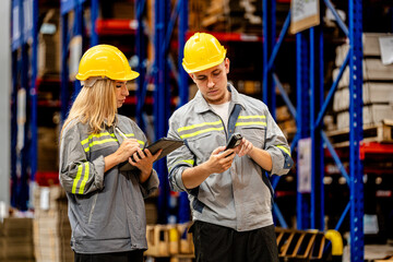 man and woman worker walking and checking stock for shipping. Female inspecting the store factory....