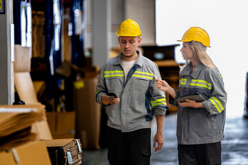 man and woman worker walking and checking stock for shipping. Female inspecting the store factory. Logistics employees holding folders at on site warehouse area for shipping transportation.