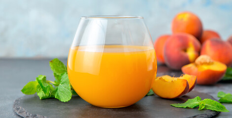 Glass of fresh peach juice on table