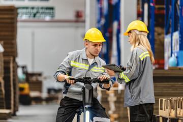 man riding electric bicycle and checking stock items for shipping. male inspecting the store factory. Logistics employees holding folders at on site warehouse area for shipping transportation.