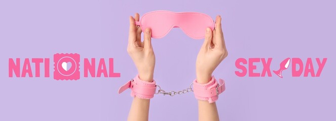 Female hands with pink handcuffs and mask from sex shop on lilac background. National Sex Day