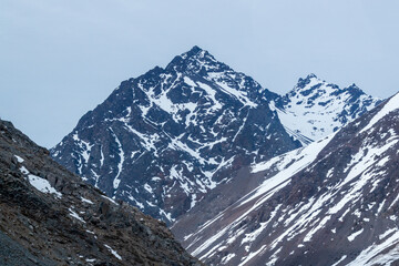A freezing day high in the Andes Mountains in Chile, with mountains covered in snow.