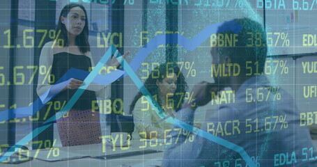 Image of stock market data processing over biracial woman talking to her colleagues at office