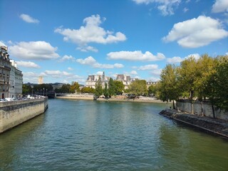 Naklejka premium Bridge over the seine river against sky. Panoramic view from a bridge spanning the seine river, town hall in the horizon in paris
