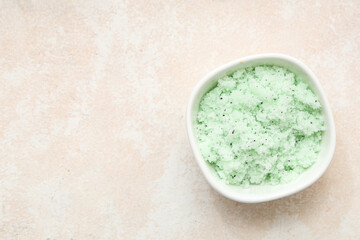 Bowl of natural body scrub on light background