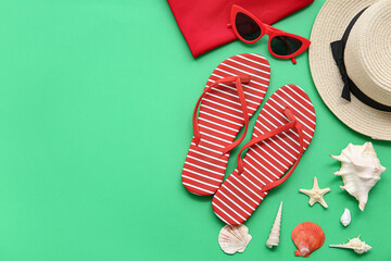 Composition with stylish beach accessories and seashells on green background