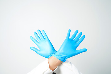 Stop gesture, arms crossed in blue gloves, sign protest, rejection, on white background