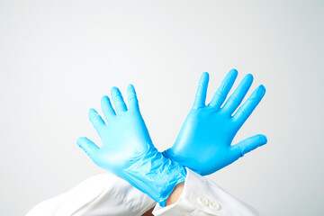 Stop gesture, arms crossed in blue gloves, sign protest, rejection, on white background