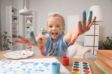 Happy little girl in paint at home
