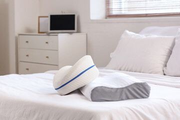 Soft orthopedic pillows on bed in room