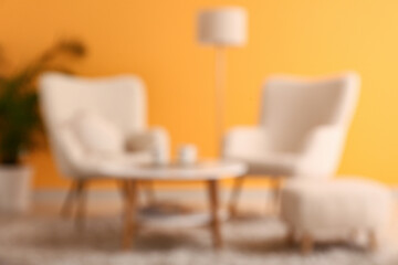 Armchairs and coffee table in living room. Blurred view