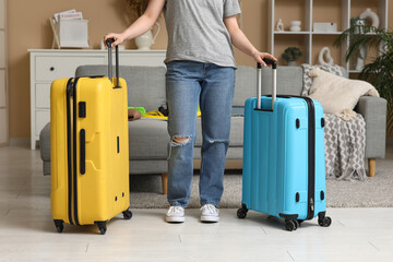 Young woman in hat with suitcases at home, closeup. Summer travel concept