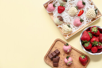 Box with chocolate covered strawberries and bowl of fresh berries on yellow background