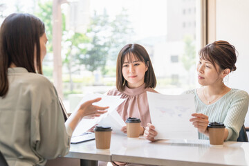 書類・資料を見ながら会議・ミーティング・打ち合わせするアジア人女性・ビジネスウーマン(営業・企画)
