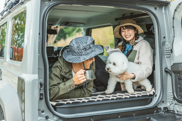 犬・ペットを連れてドライブ・デイキャンプ・キャンプ・車中泊する若いアジア人カップル・夫婦・キャンパー
