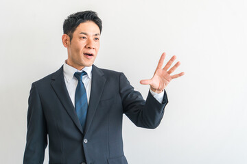 手のひらを拡げるスーツ姿の中年アジア人ビジネスマン（拒否・驚く・注意・びっくり・ダメ・止める）
