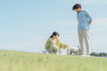 愛犬を可愛がる飼い主の親子・犬の散歩（父親と娘）
