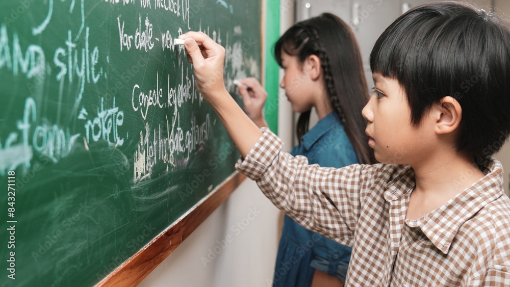 Poster side view of asian boy writing engineering prompt and programing system while standing blackboard wi
