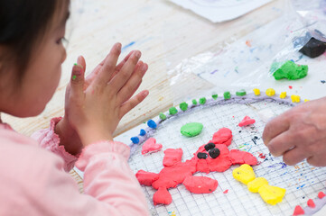 絵画教室で粘土を使った工作に励む小学生の子ども