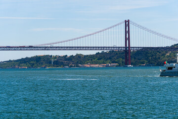 Obraz premium The 25th April Bridge, Ponte 25 de Abril in Portuguese, the longest suspension bridge in Europe. Connecting the city of Lisbon, capital of Portugal, to the municipality of Almada over the Tagus River.
