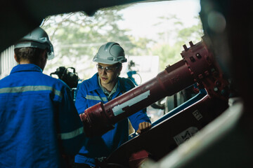 Teamwork of male engineers checking and maintaining the quality of the robot arm, robot arm factory Technology and engineering concepts.