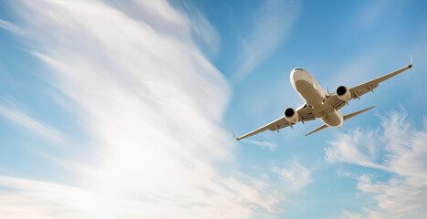 White passenger airplane flying in the sky amazing clouds in the background - Travel by air...