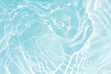 Obraz premium Blue water with ripples on the surface. Defocus blurred transparent blue colored clear calm water surface texture with splashes and bubbles. Water waves with shining pattern texture background.