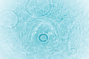 Blue water with ripples on the surface. Defocus blurred transparent blue colored clear calm water surface texture with splashes and bubbles. Water waves with shining pattern texture background.