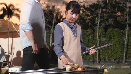 Family gather celebrate holiday, Adorable child grill food for family member. Outdoor camping...