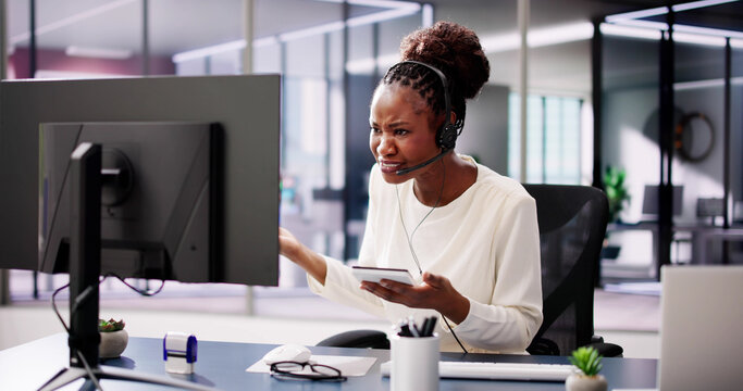 Worried African American businesswoman in office uses headset - Powered by Adobe
