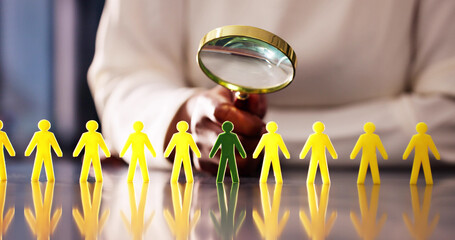 African American woman using a magnifying glass to select diverse candidates