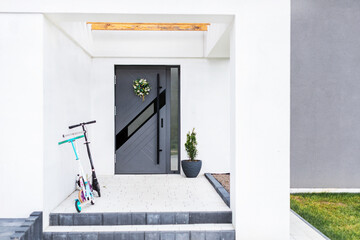 Designer entrance door to a country house. Modern design. Luxurious exterior. Facade of a modern building with modern doors.