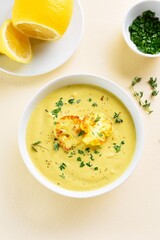 Cauliflower cheese soup in bowl over light background