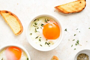 Eggs en cocotte (baked eggs) with cream, сheese and herbs