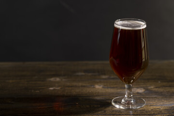 dark beer in a glass glass, fresh dark alcoholic beer
